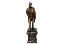 a bronze statue of a man standing on a pedestal