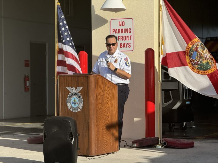 a man standing at a podium in front of a flag