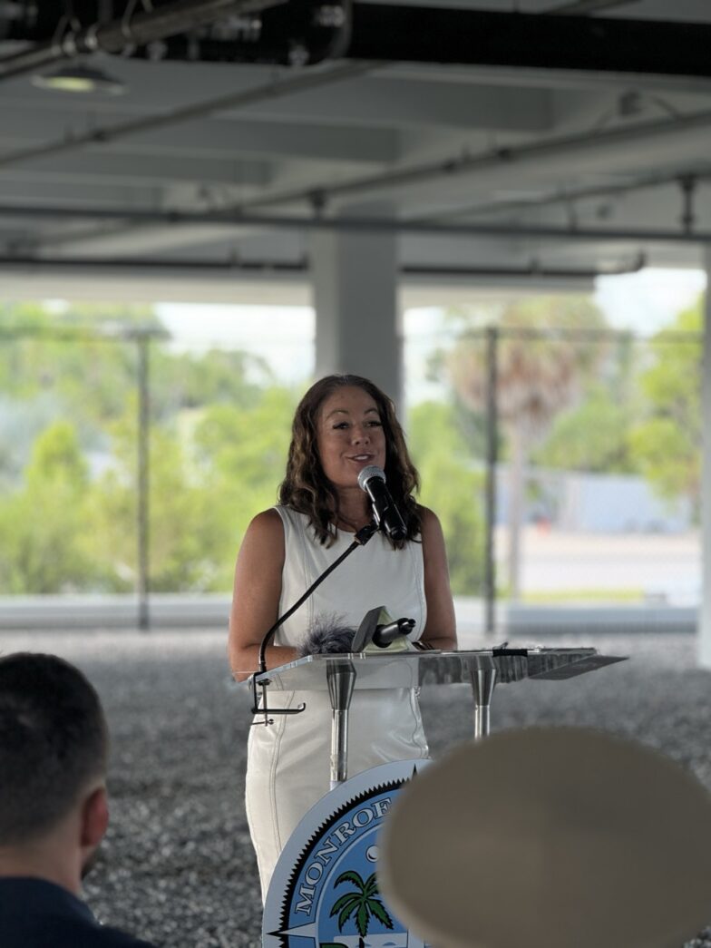 a woman standing at a podium in front of a group of people