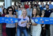 a group of people holding a blue ribbon