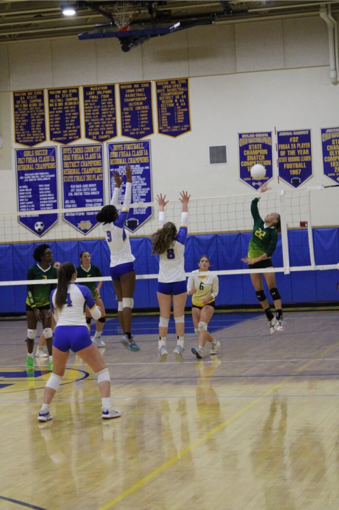 a group of girls playing a game of volleyball