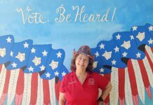 a woman standing in front of a painting of an eagle