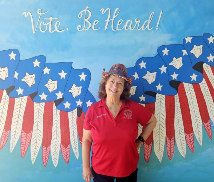 a woman standing in front of a painting of an eagle