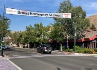 a street with a sign and cars on it