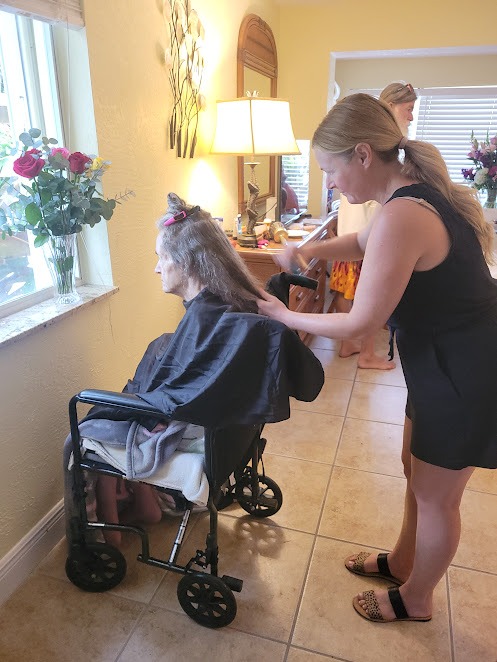 a woman standing next to a woman in a wheel chair