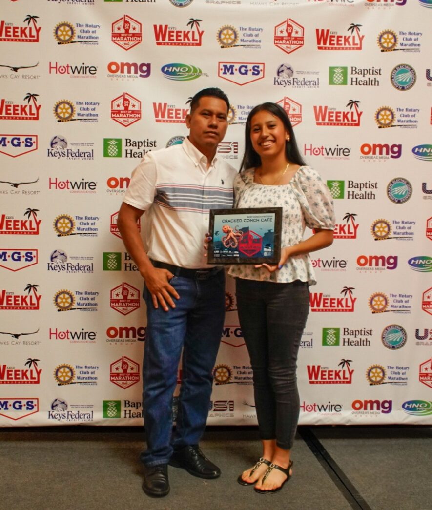 a man standing next to a woman holding a framed picture