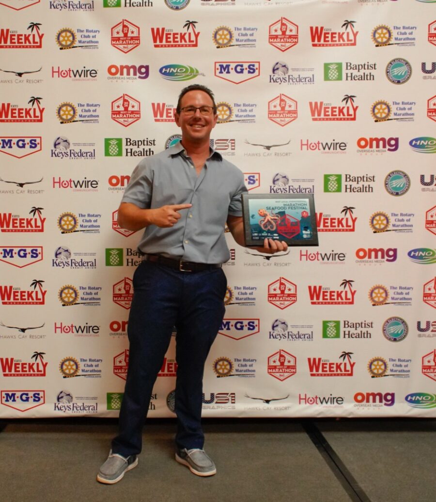 a man standing in front of a wall holding a book