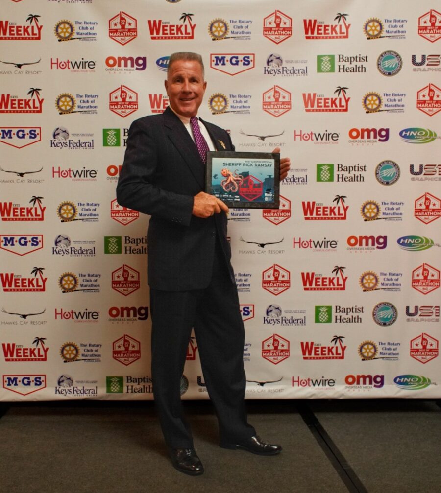 a man in a suit and tie holding a plaque