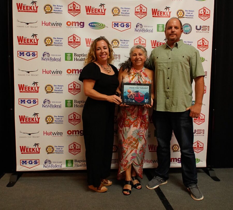 a man standing next to a woman holding a plaque