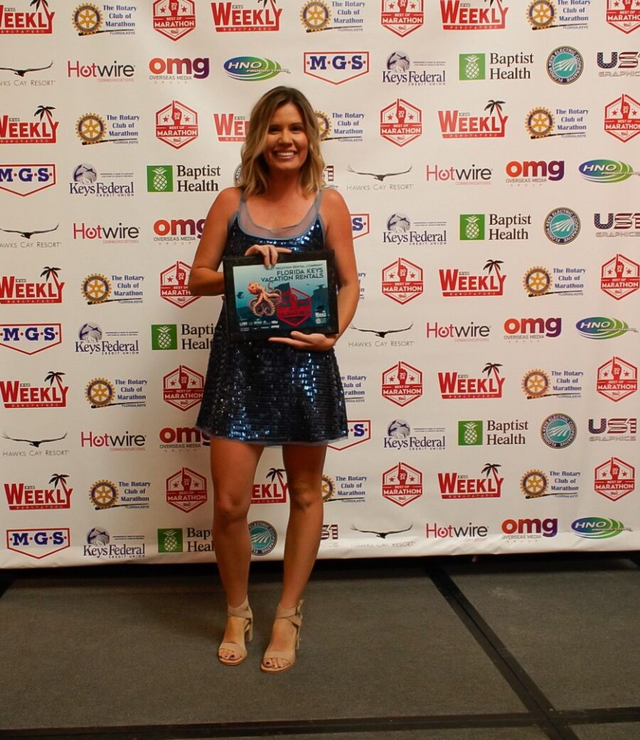 a woman standing in front of a wall holding a book