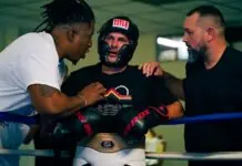 a group of men standing around each other in a boxing ring