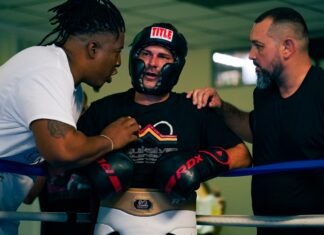 a group of men standing around each other in a boxing ring