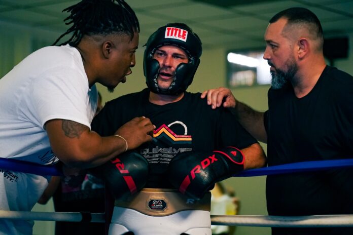 a group of men standing around each other in a boxing ring