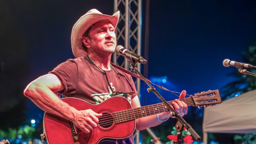 a man in a cowboy hat playing a guitar