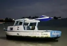 a white and blue boat sitting on top of a beach