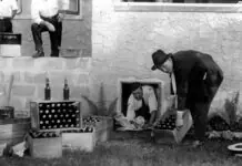 a black and white photo of a man opening a box