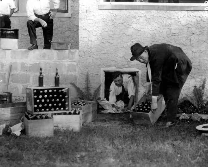 a black and white photo of a man opening a box