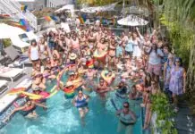 a group of people standing around a swimming pool