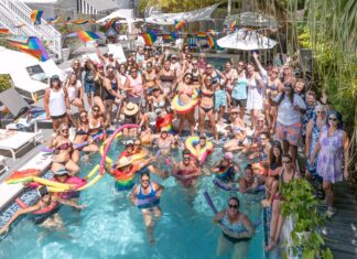 a group of people standing around a swimming pool