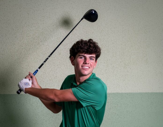 a man in a green shirt swinging a golf club