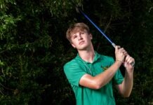 a man in a green shirt holding a golf club