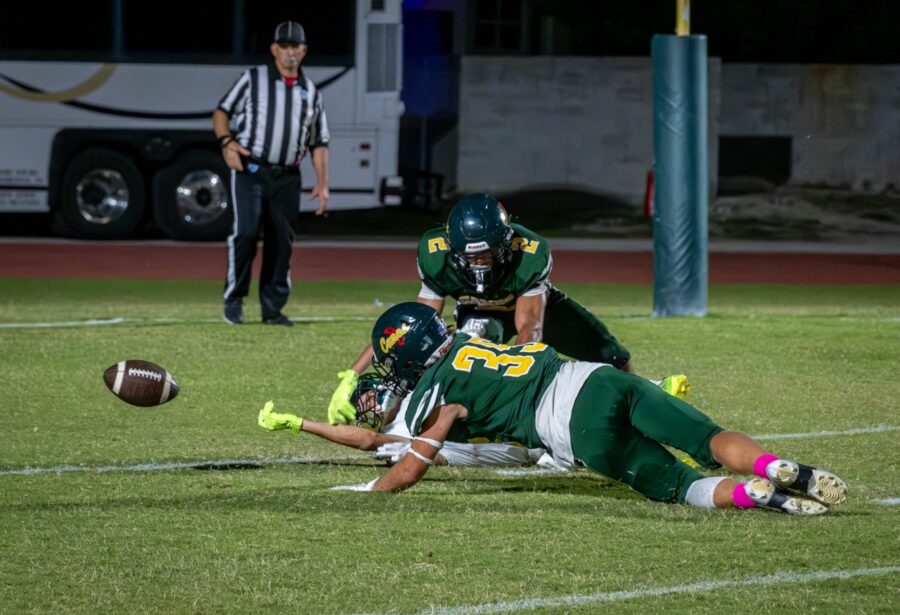 a football player laying on the ground with a ball