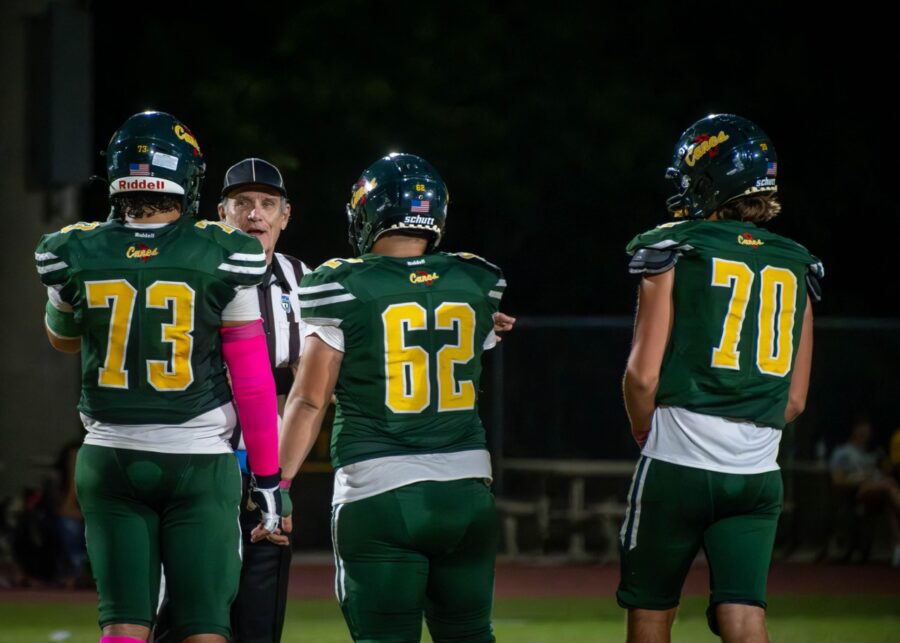 a group of football players standing on top of a field