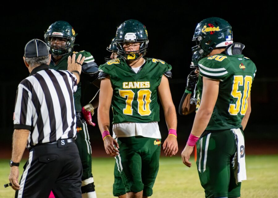 a group of football players standing on top of a field