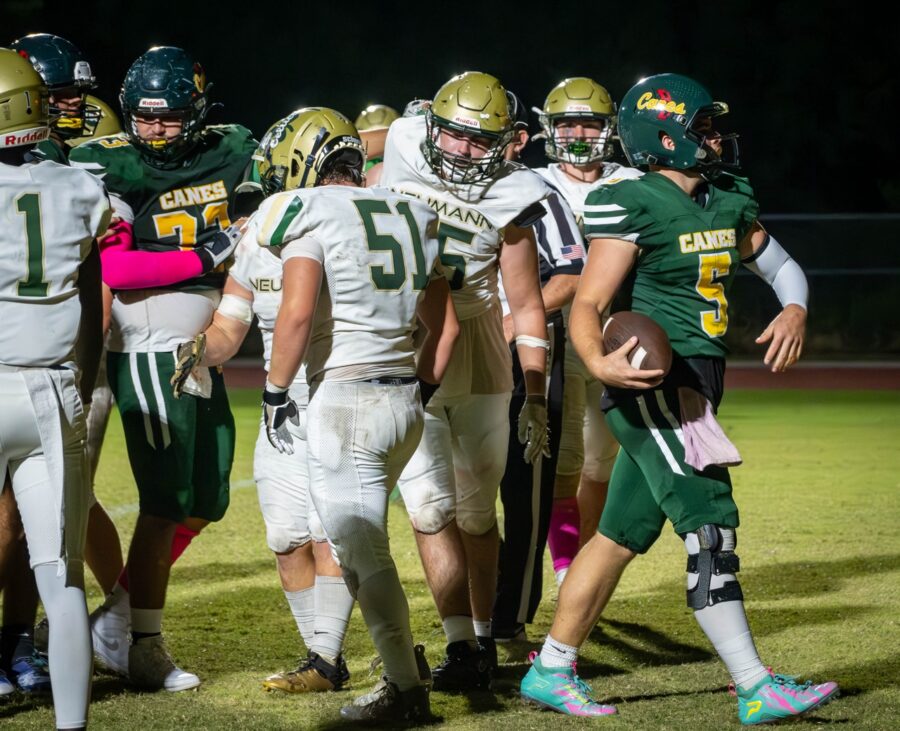 a group of football players huddle together on the field