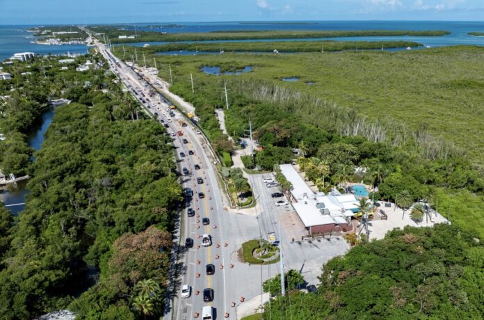 an aerial view of a road and a body of water