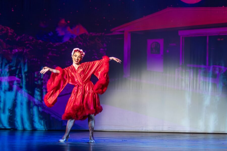 a woman in a red dress dancing on a stage