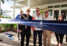 a group of people cutting a ribbon at a ribbon cutting ceremony