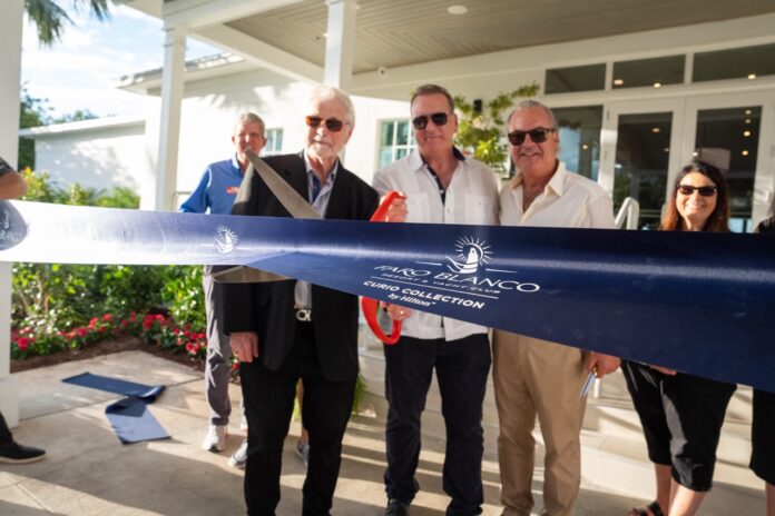 a group of people cutting a ribbon at a ribbon cutting ceremony