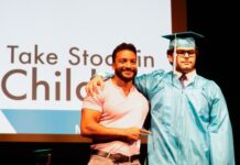 a couple of men standing next to each other on a stage