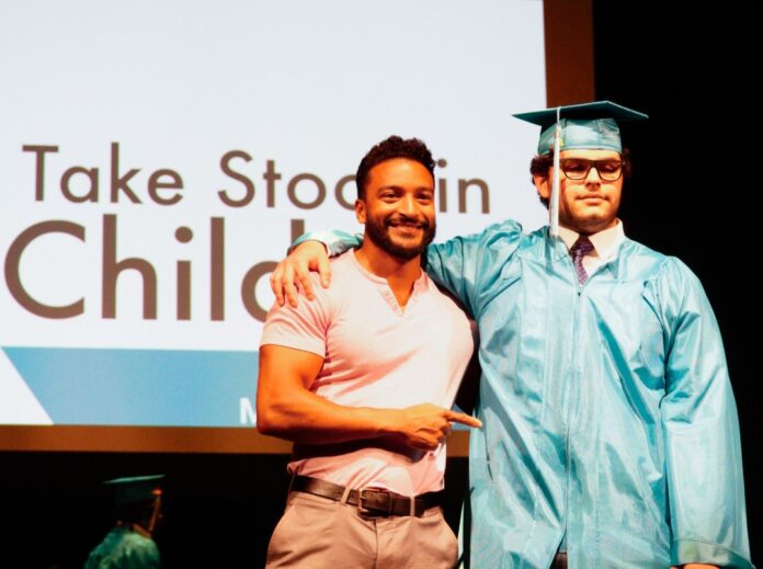 a couple of men standing next to each other on a stage