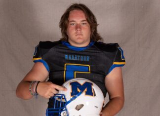 a man in a football uniform holding a helmet