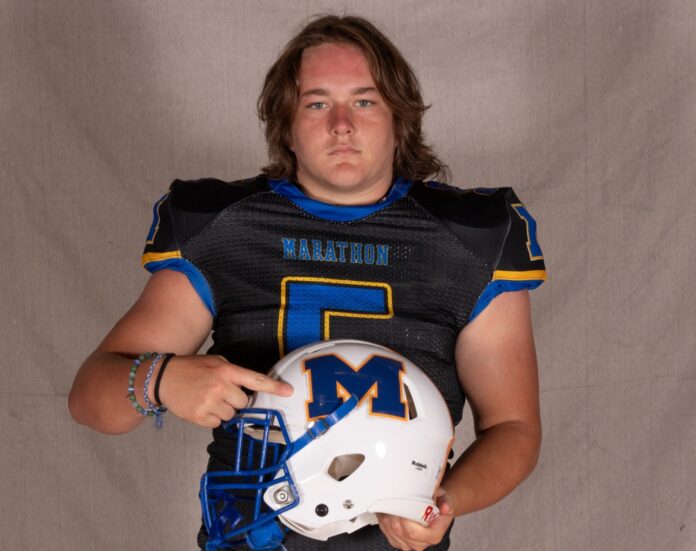 a man in a football uniform holding a helmet