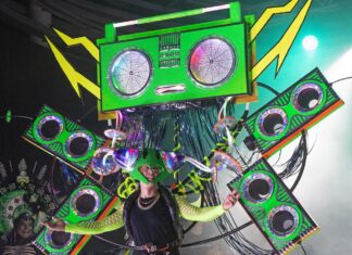 a person standing on a stage with a green box on their head