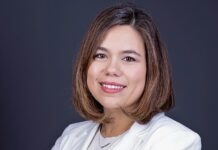 a woman in a white suit smiling at the camera