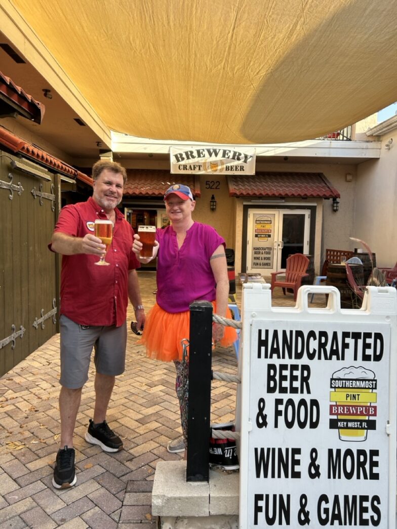 a man and a woman standing next to a sign