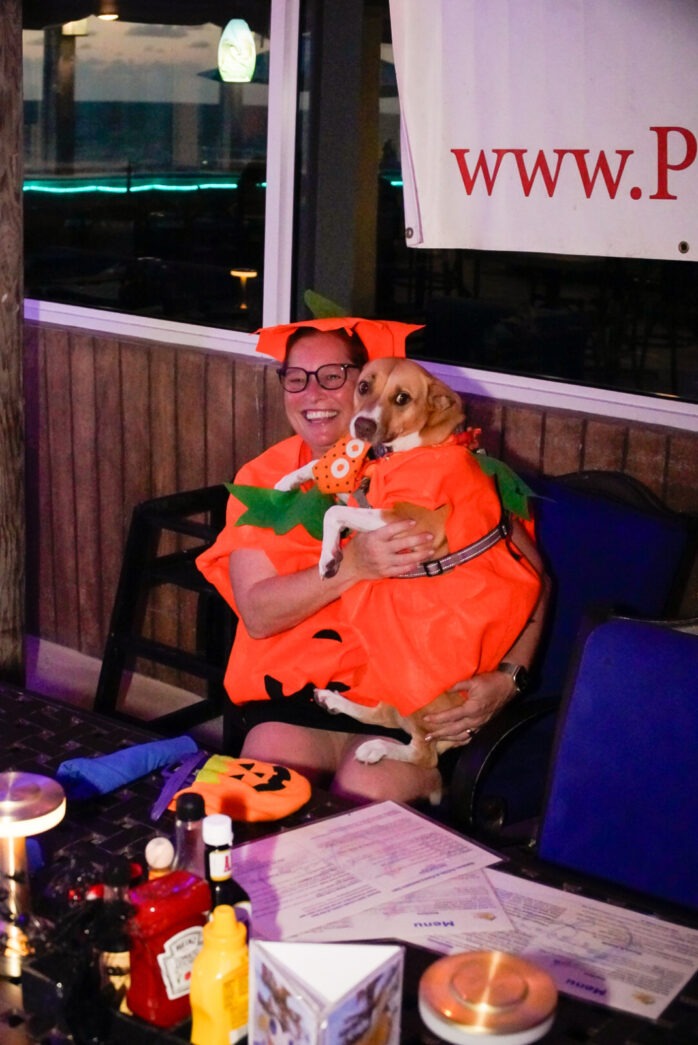 a man sitting at a table holding a dog