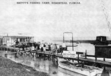 a black and white photo of a boat docked at a pier