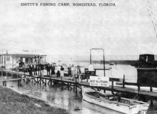 a black and white photo of a boat docked at a pier