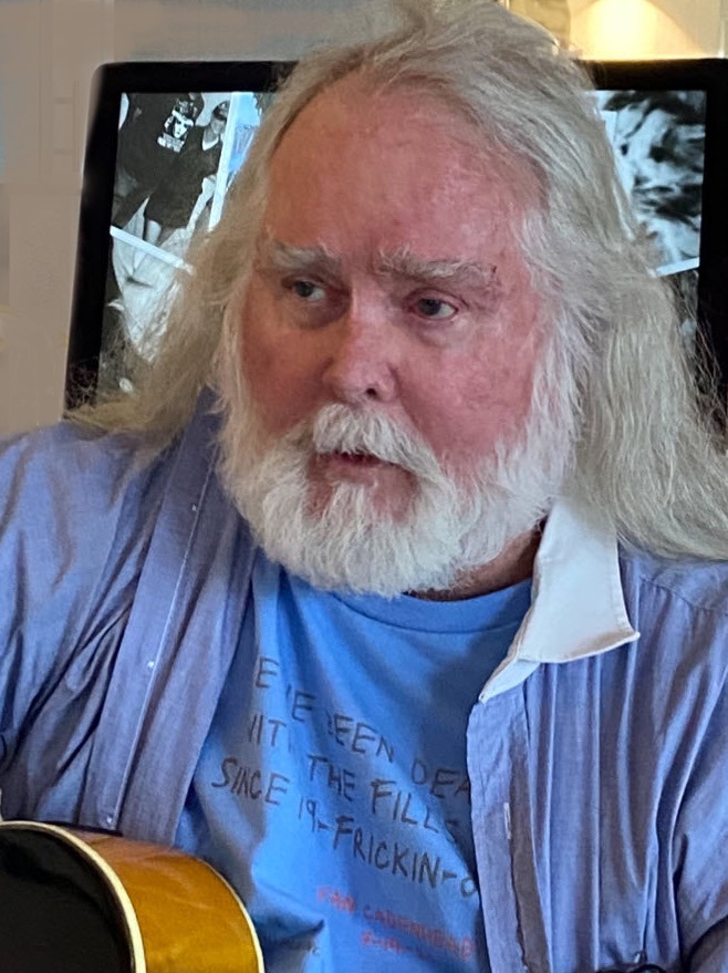 a man with long white hair and a beard holding a guitar