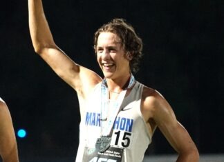 a man holding up a trophy in front of him