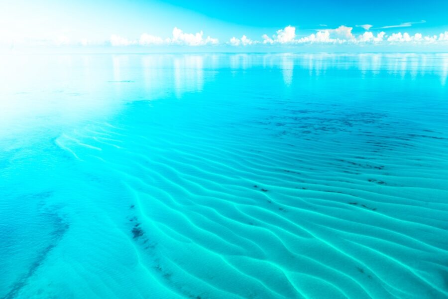 a sandy beach with a bright blue sky in the background