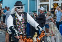 a man in a costume riding a bike down the street