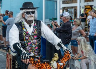 a man in a costume riding a bike down the street