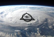 an eye in the center of a triangle on top of the earth