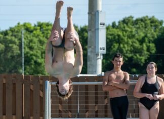 a group of people standing around a swimming pool